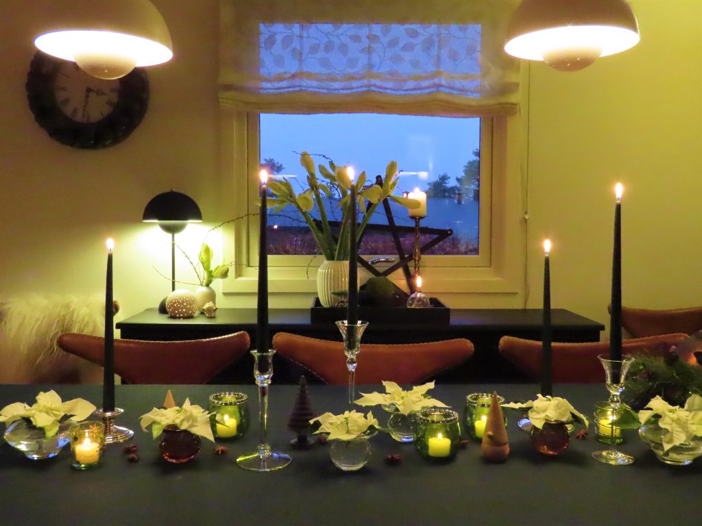 Vakker og stemningsfull borddekking med hvite julestjerner - julebordet sett mot sjenken og vinduet